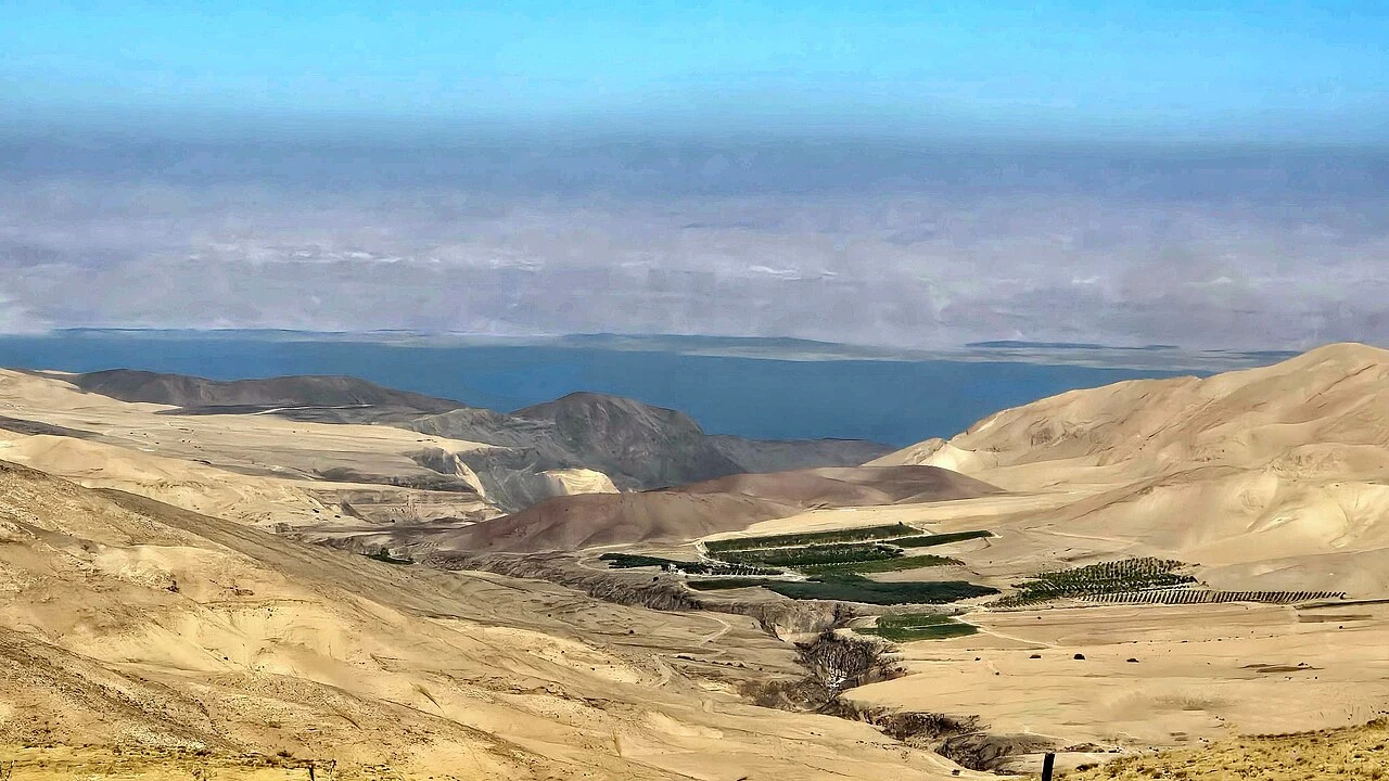 Dry hills, cultivated land and the distant Dead Sea viewed from Mukawir in Jordan